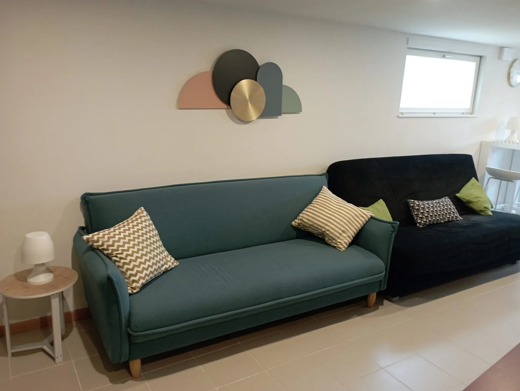 Second salon du gîte avec deux canapés et une décoration murale contemporaine.